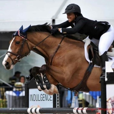 Joan Wandolo smiling while horseback riding in a competition.