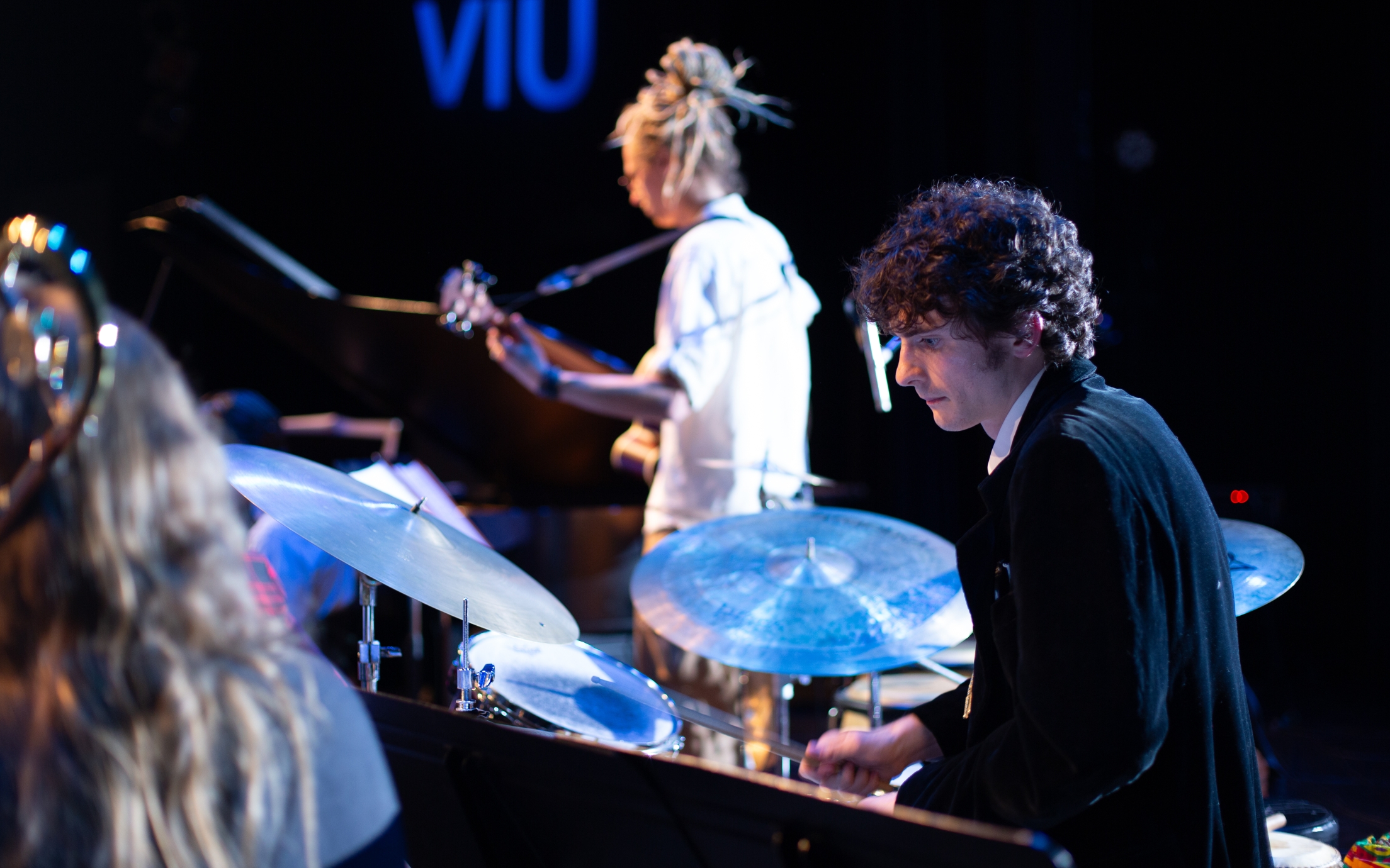 A drummer and a guitarist on stage.