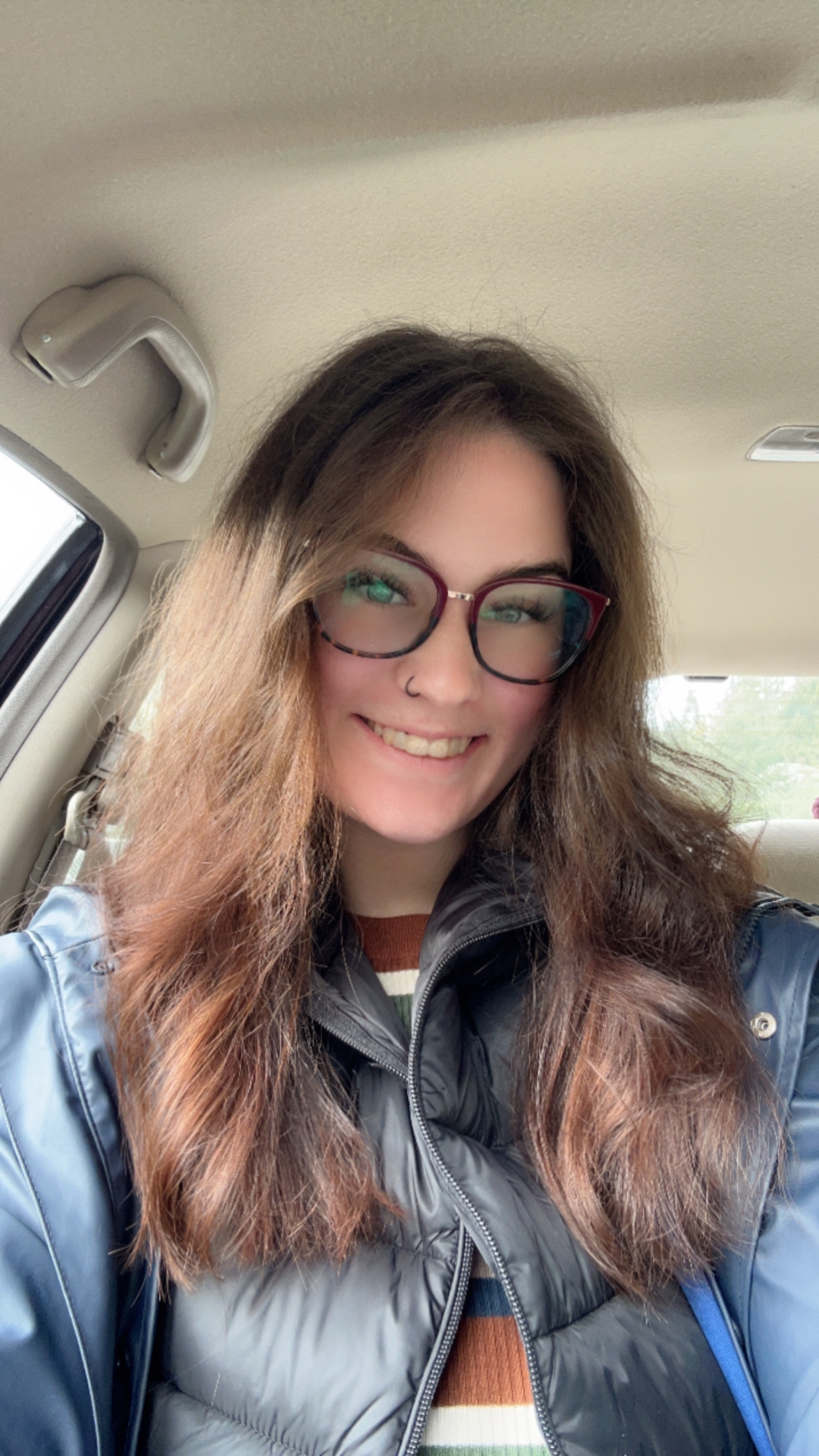 Brunette haired woman with glasses smiling