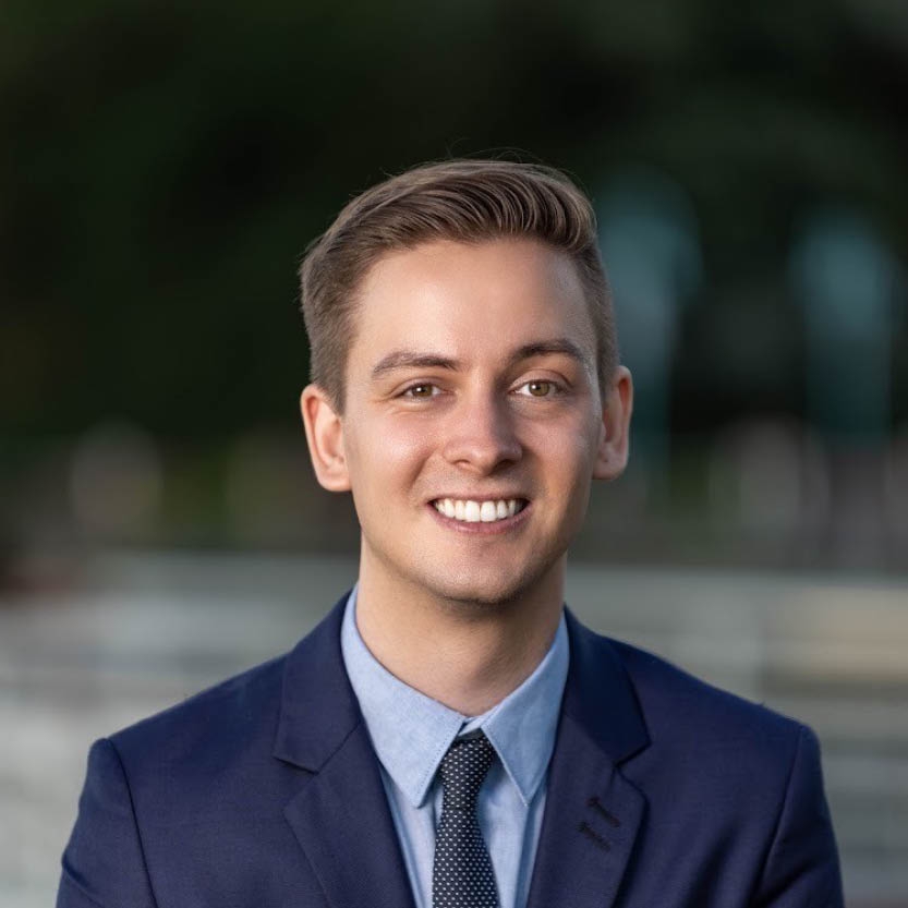 A smiling young man in a suit.