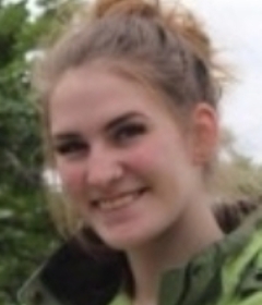 Smiling blond-haired woman wearing a green jacket