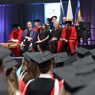 Dr. Dave Hopwood (green gown) as a member of the stage party.  June 22, 2023.